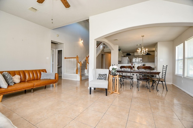 dining room with stairs, ceiling fan with notable chandelier, light tile patterned flooring, and visible vents