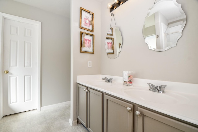 full bath with a sink, baseboards, and double vanity