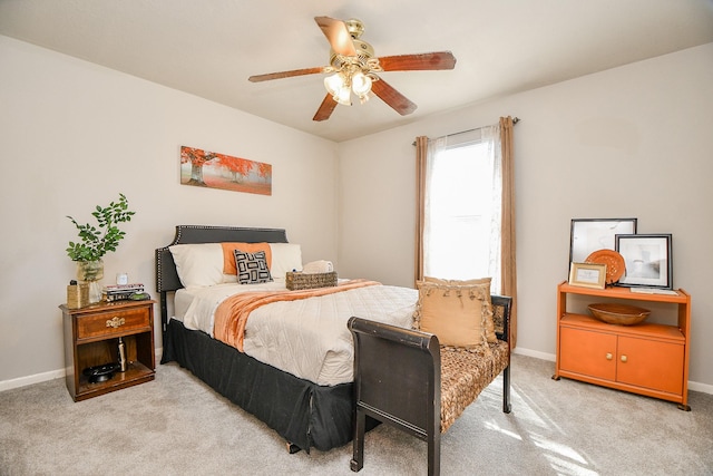 bedroom featuring a ceiling fan, light colored carpet, and baseboards