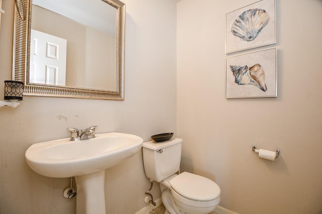 bathroom with baseboards and toilet