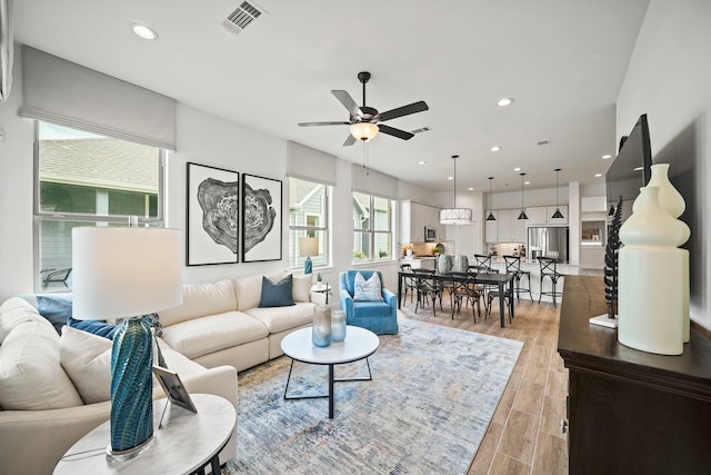 living room with ceiling fan and light hardwood / wood-style floors