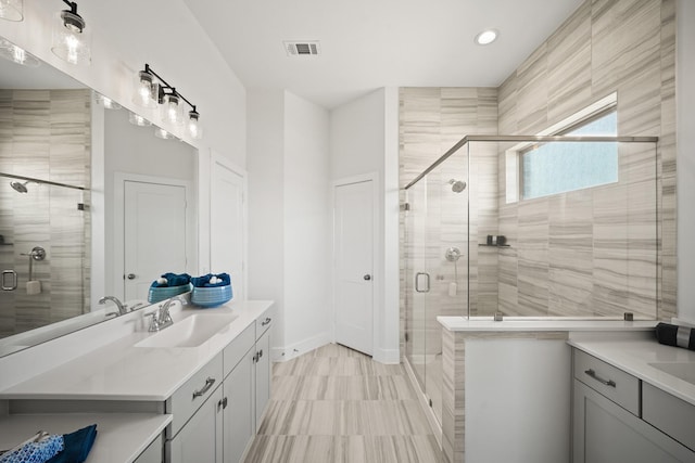 bathroom featuring vanity and a shower with door