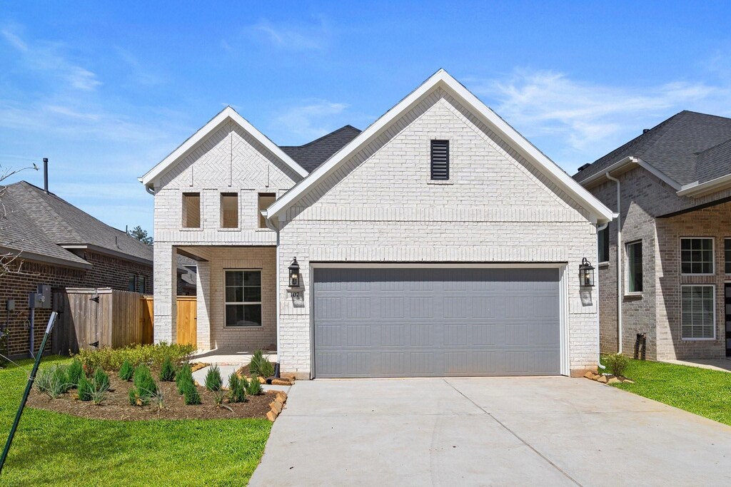 107 Sea Foam Ct, Willis, TX 77318 - view of front of property featuring an attached garage, driveway, fence, and brick siding