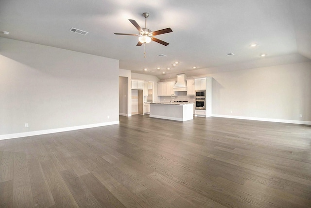 unfurnished living room featuring dark hardwood / wood-style flooring and ceiling fan