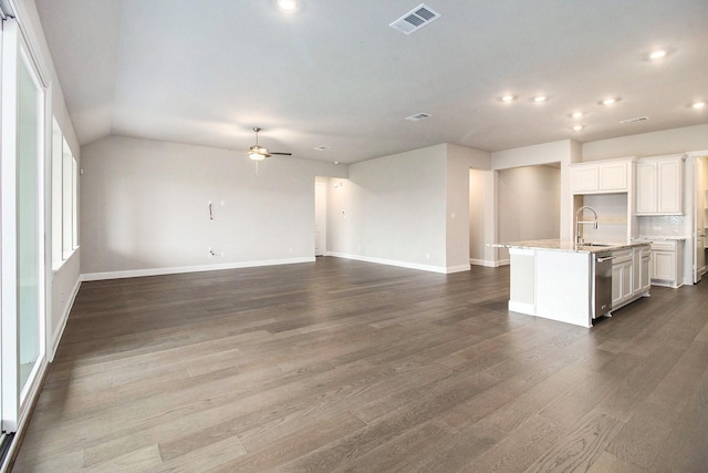 kitchen featuring a center island with sink, white cabinets, sink, ceiling fan, and tasteful backsplash