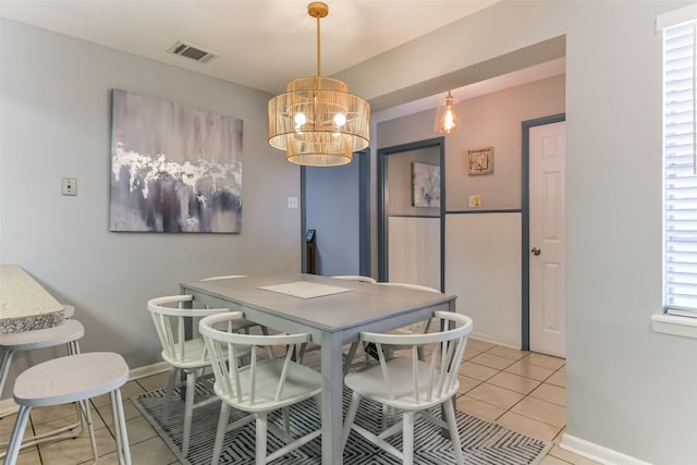 dining room with light tile patterned floors and an inviting chandelier