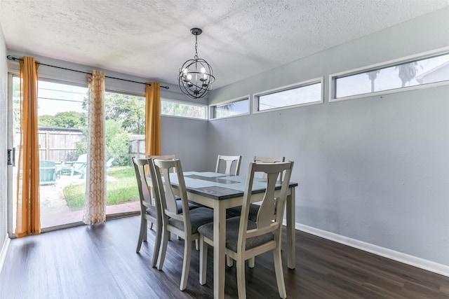 dining space with dark hardwood / wood-style flooring, a textured ceiling, and an inviting chandelier