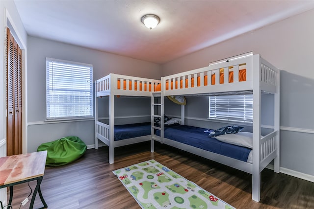 bedroom with dark hardwood / wood-style floors and a closet