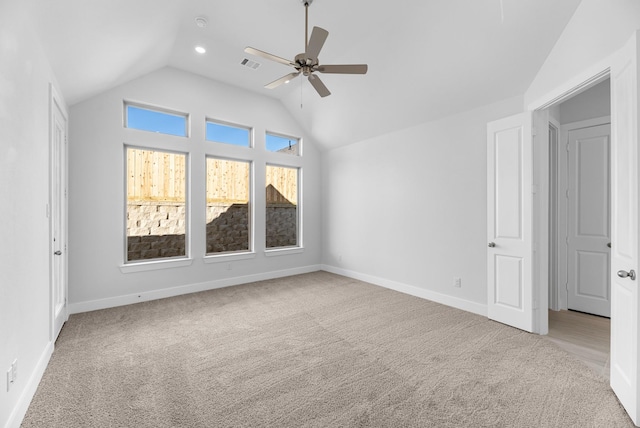 carpeted spare room with vaulted ceiling and ceiling fan