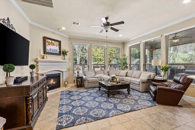 tiled living room featuring ceiling fan, ornamental molding, and a textured ceiling