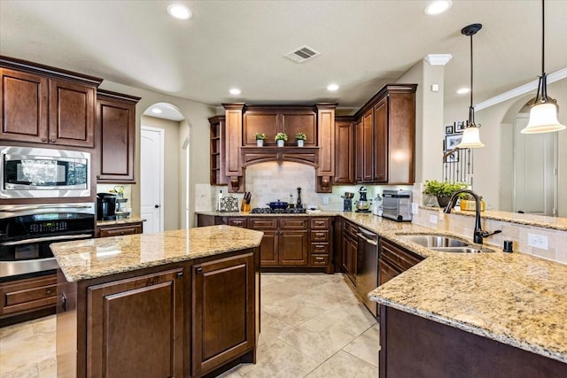 kitchen with kitchen peninsula, light stone countertops, stainless steel appliances, sink, and pendant lighting