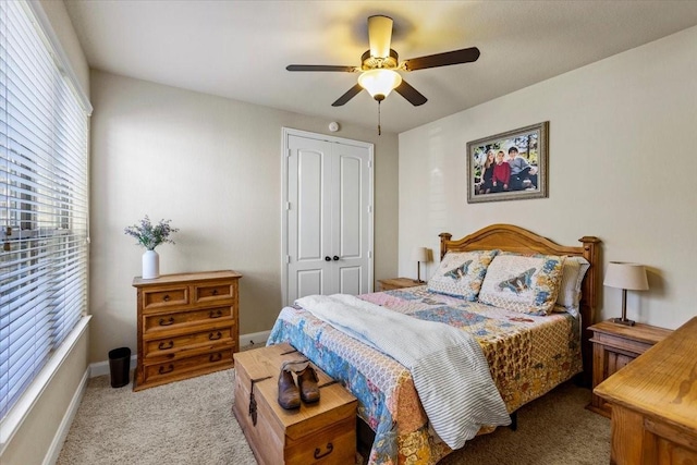 carpeted bedroom with ceiling fan and a closet