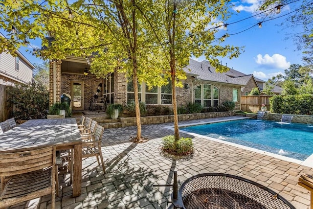 view of swimming pool with pool water feature, ceiling fan, and a patio