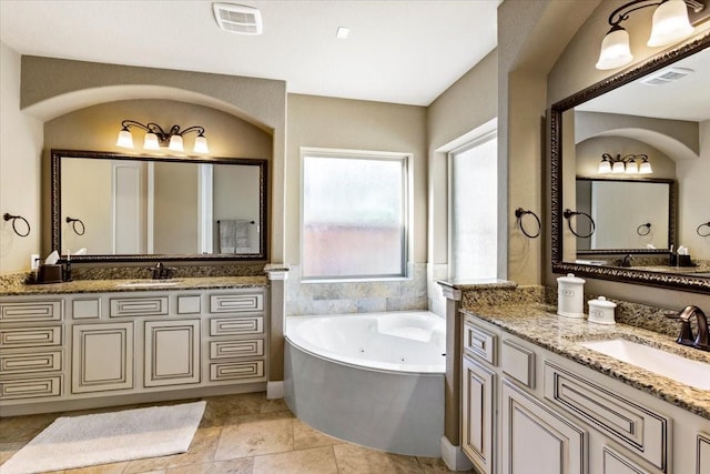 bathroom with tile patterned flooring, vanity, and a washtub