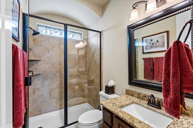 bathroom with vanity, toilet, and a shower with door