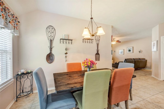 tiled dining space featuring ceiling fan with notable chandelier and lofted ceiling