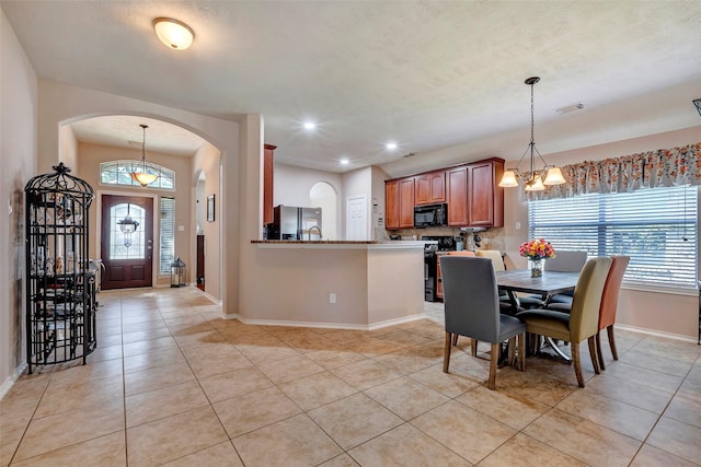 tiled dining space with a notable chandelier