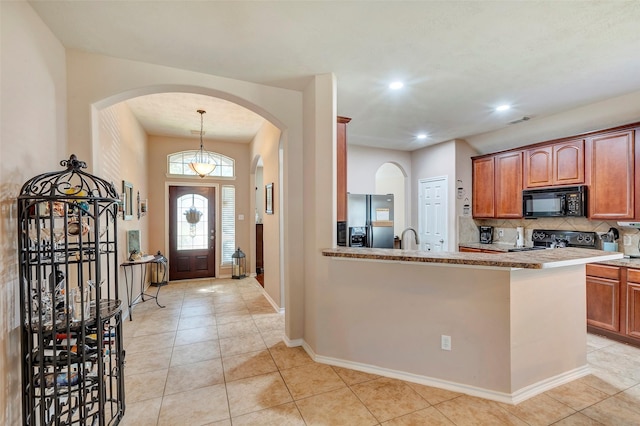 kitchen featuring backsplash, range, sink, stainless steel fridge with ice dispenser, and light tile patterned flooring