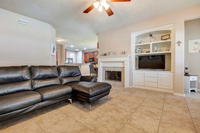 tiled living room featuring a fireplace, ceiling fan, and built in features