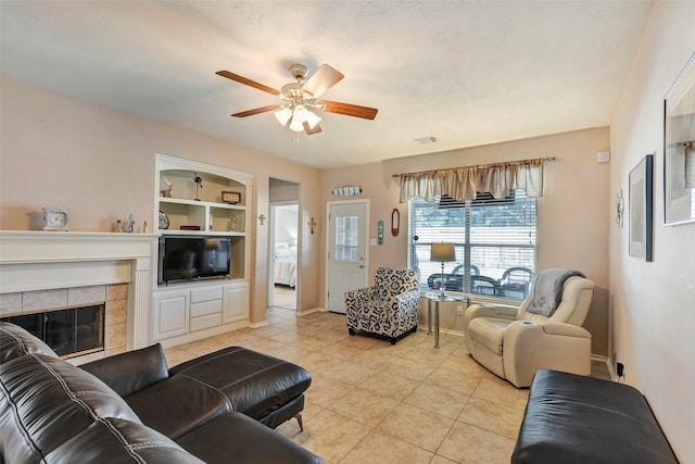 tiled living room featuring ceiling fan, built in features, and a fireplace