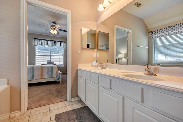 bathroom with ceiling fan, tile patterned flooring, vanity, and vaulted ceiling