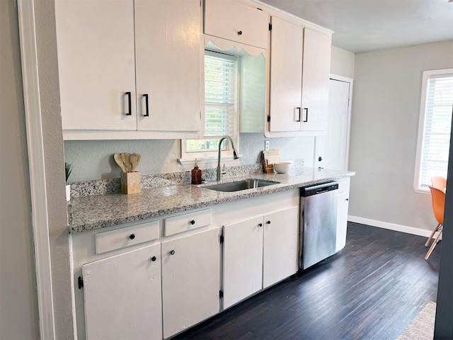 kitchen with dishwasher, sink, light stone countertops, a healthy amount of sunlight, and white cabinetry