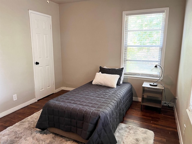 bedroom with dark hardwood / wood-style flooring