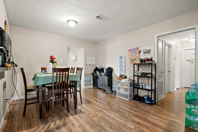 dining area with a textured ceiling and hardwood / wood-style flooring