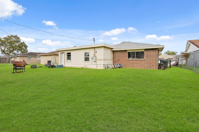 rear view of property featuring a lawn