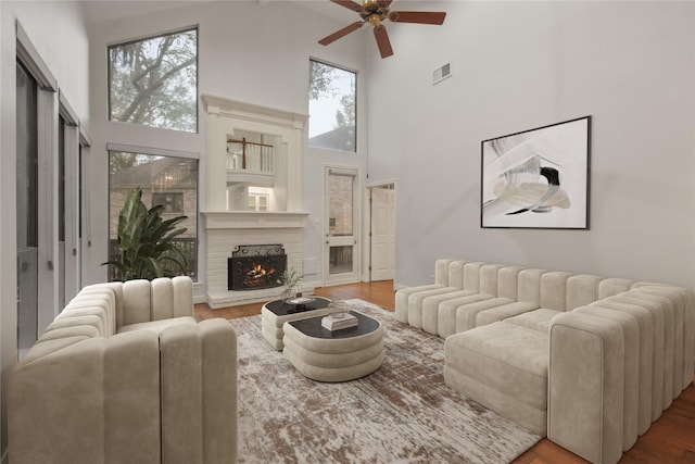 living room with ceiling fan, high vaulted ceiling, and wood-type flooring