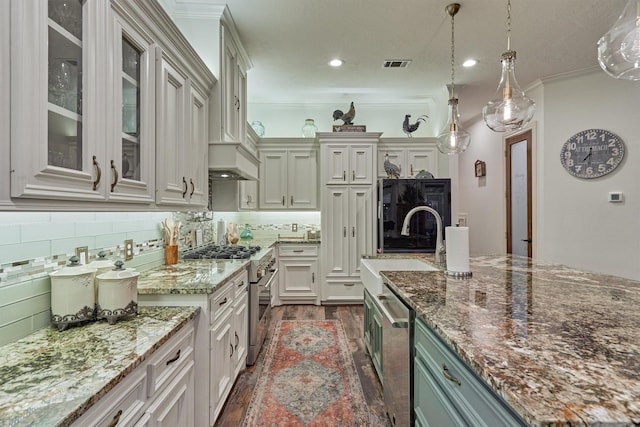 kitchen featuring pendant lighting, dark wood-type flooring, light stone countertops, appliances with stainless steel finishes, and tasteful backsplash