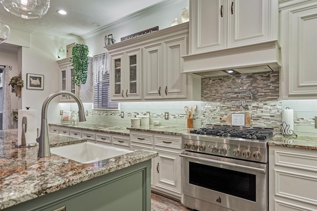 kitchen featuring stainless steel range, sink, tasteful backsplash, premium range hood, and crown molding