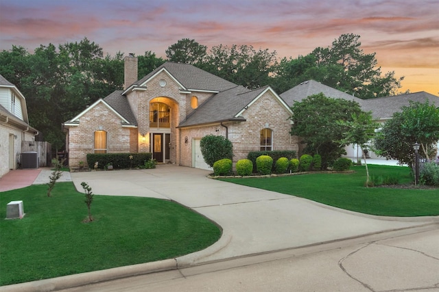 view of front facade featuring a garage, cooling unit, and a lawn