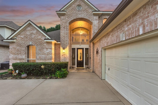 exterior entry at dusk with a garage and central AC