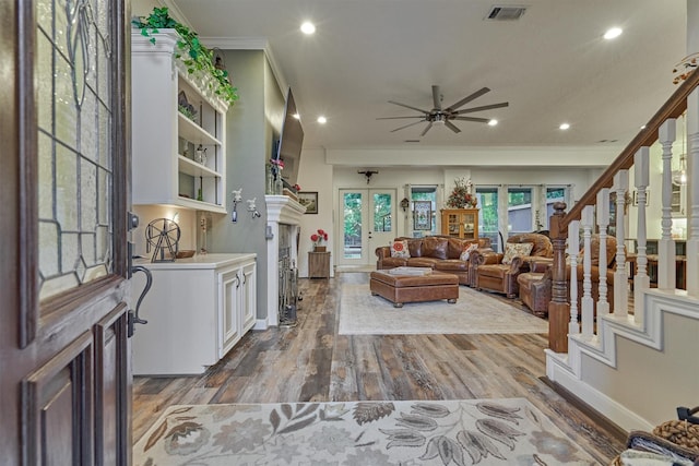 living room featuring ceiling fan, wood-type flooring, and ornamental molding