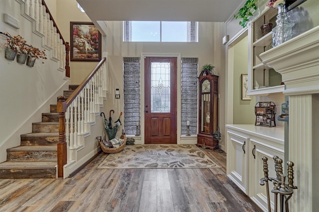 foyer entrance with hardwood / wood-style floors and a high ceiling