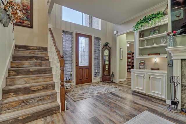 foyer entrance with crown molding and dark wood-type flooring