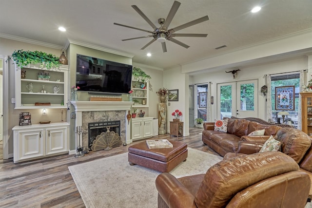 living room featuring french doors, light hardwood / wood-style flooring, ceiling fan, and ornamental molding