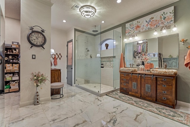 bathroom featuring vanity, ornamental molding, a textured ceiling, and a shower with shower door