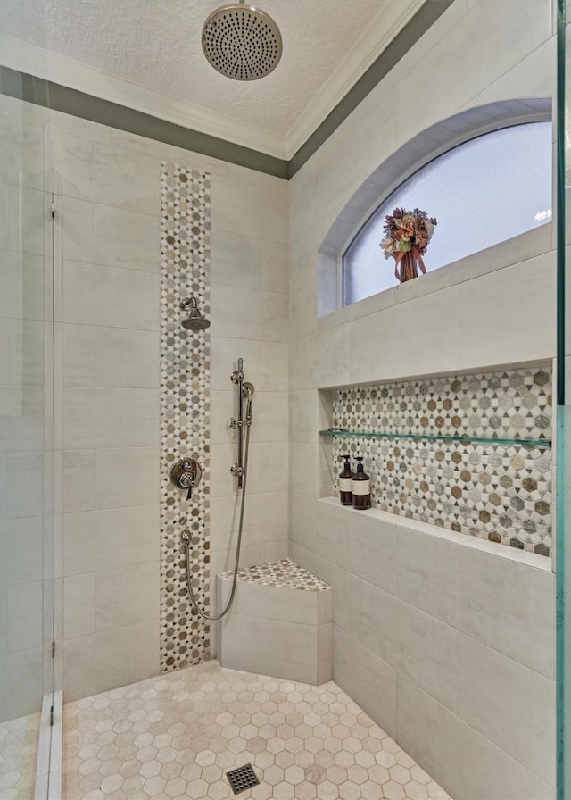 bathroom featuring crown molding, a tile shower, and a textured ceiling