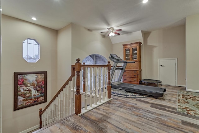 exercise room featuring ceiling fan, lofted ceiling, and hardwood / wood-style flooring