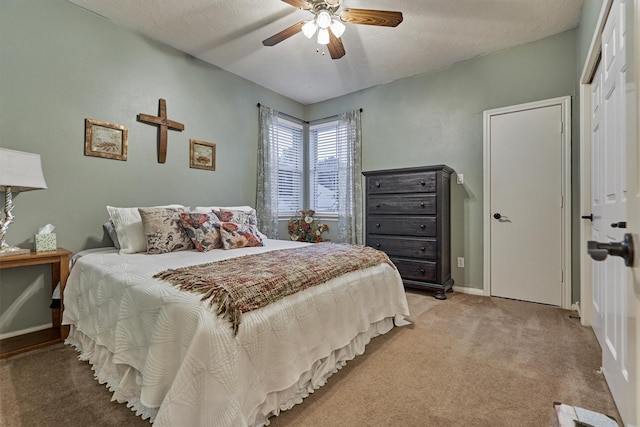 bedroom featuring a textured ceiling, ceiling fan, light carpet, and a closet