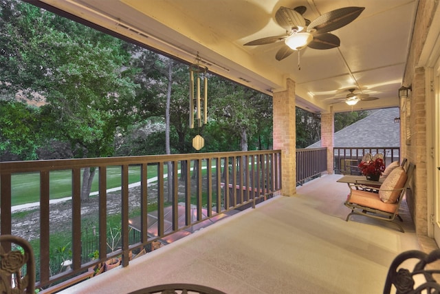 view of patio with ceiling fan and a balcony