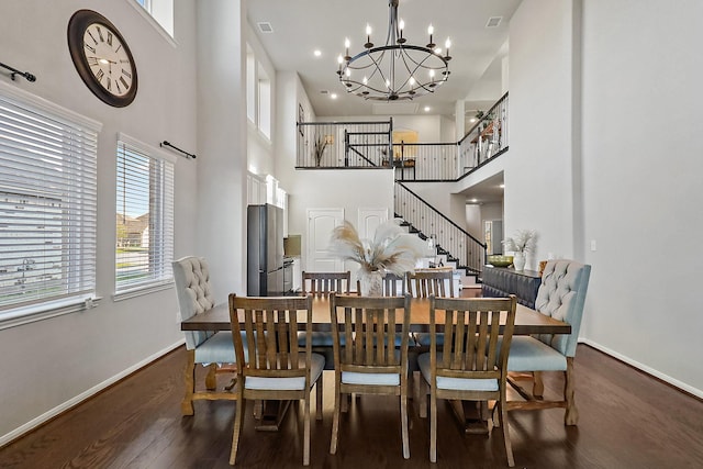 dining area featuring a chandelier, a high ceiling, and dark wood-type flooring