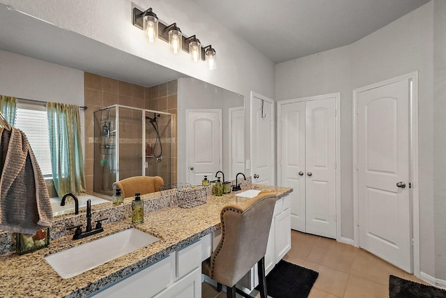 bathroom with tile patterned flooring, vanity, and walk in shower