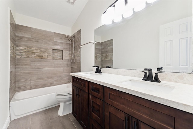 full bathroom with vanity, toilet, lofted ceiling, and tiled shower / bath