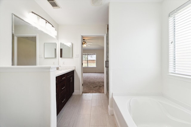 bathroom featuring vanity, a bathtub, and ceiling fan