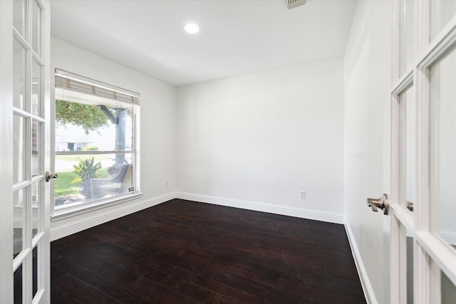 empty room featuring hardwood / wood-style floors, a healthy amount of sunlight, and french doors