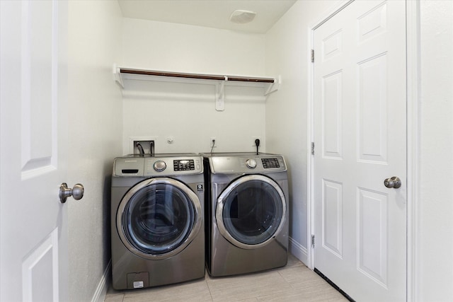 laundry room featuring independent washer and dryer and light tile patterned flooring