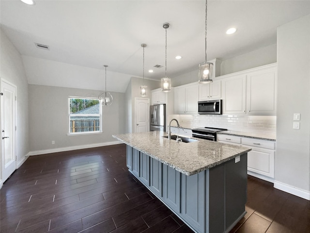 kitchen featuring appliances with stainless steel finishes, white cabinetry, vaulted ceiling, and decorative light fixtures